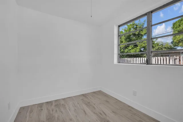a view of a small space with wooden floor and a window