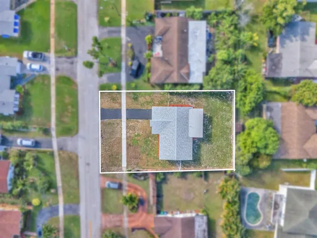 an aerial view of residential houses with outdoor space and swimming pool