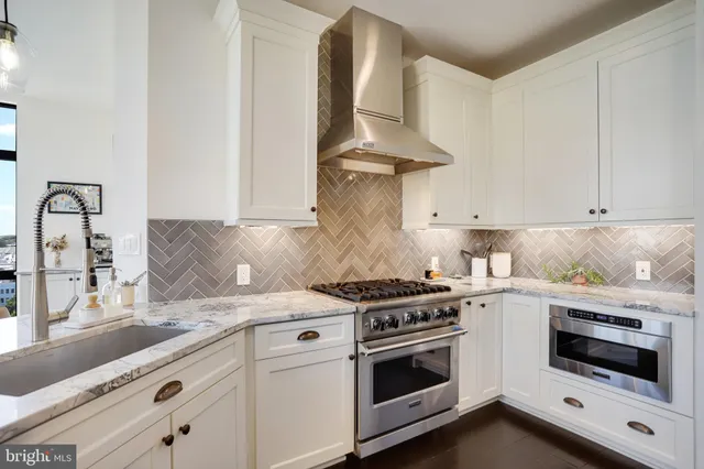 a kitchen with a refrigerator and white cabinets