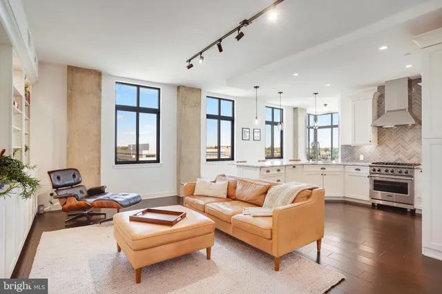 a kitchen with stainless steel appliances granite countertop a stove refrigerator and a view of living room