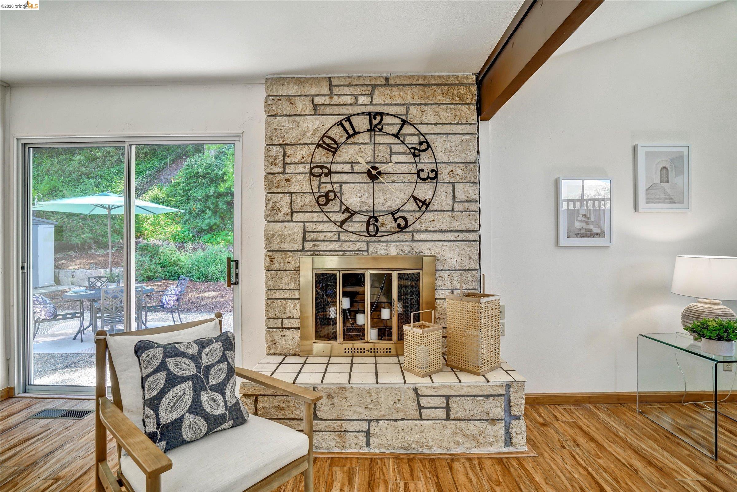 2826 Wright Avenue Pinole, CA 94564 - Photo 11 of 70 Stone-clad fireplace with brass insert, wood-finish flooring, and exposed ceiling beam
