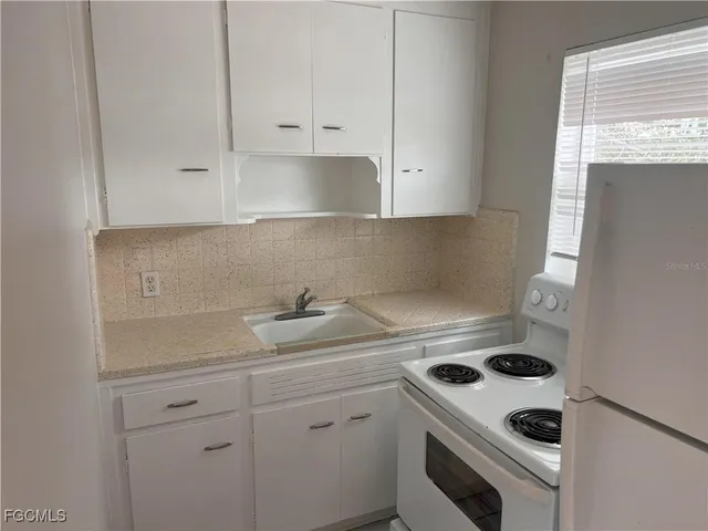 a kitchen with a sink a stove and cabinets