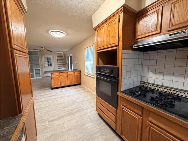 a kitchen with granite countertop stainless steel appliances and wooden cabinets