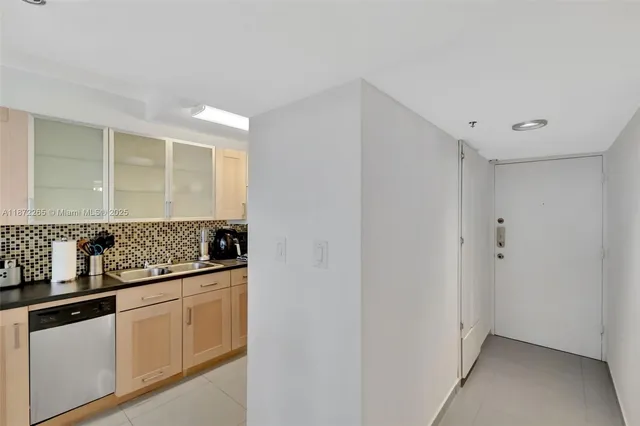 a bathroom with a sink a mirror and a potted plant