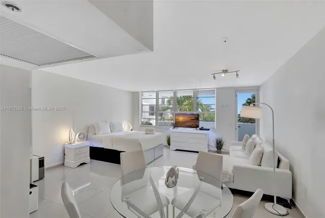 a bedroom with a white bed and dresser