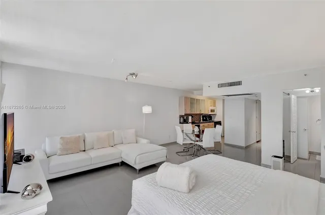 a bedroom with a bed a couch and a window