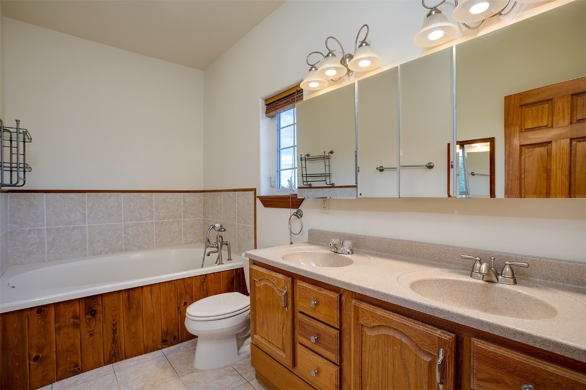 1170 Fish Creek Falls Road Steamboat Springs, CO 80487 - Photo 11 of 24 a bathroom with a toilet a sink a tub and mirror