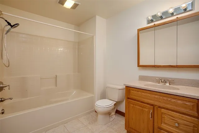 a bathroom with a granite countertop toilet a sink and bathtub