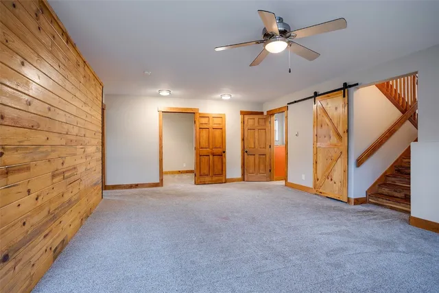 a view of an empty room with a ceiling fan and window