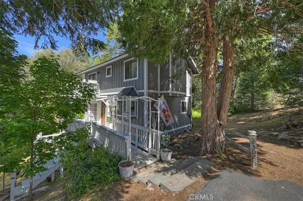 a view of house with large trees and a small yard