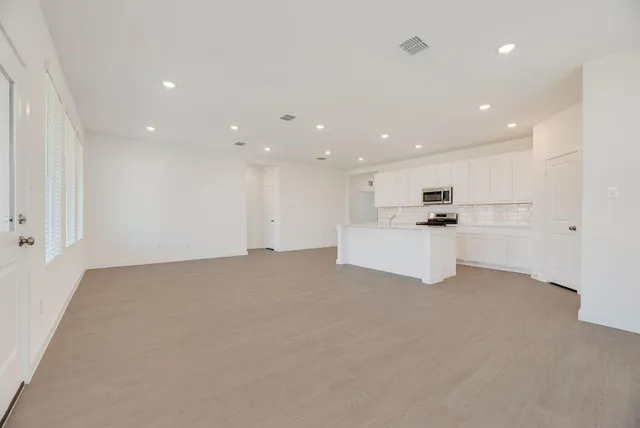 a view of kitchen with kitchen island and stainless steel appliances
