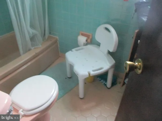 a white toilet sitting next to a bathroom sink and tub