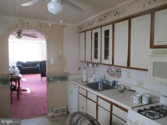 a kitchen with sink a stove and cabinets