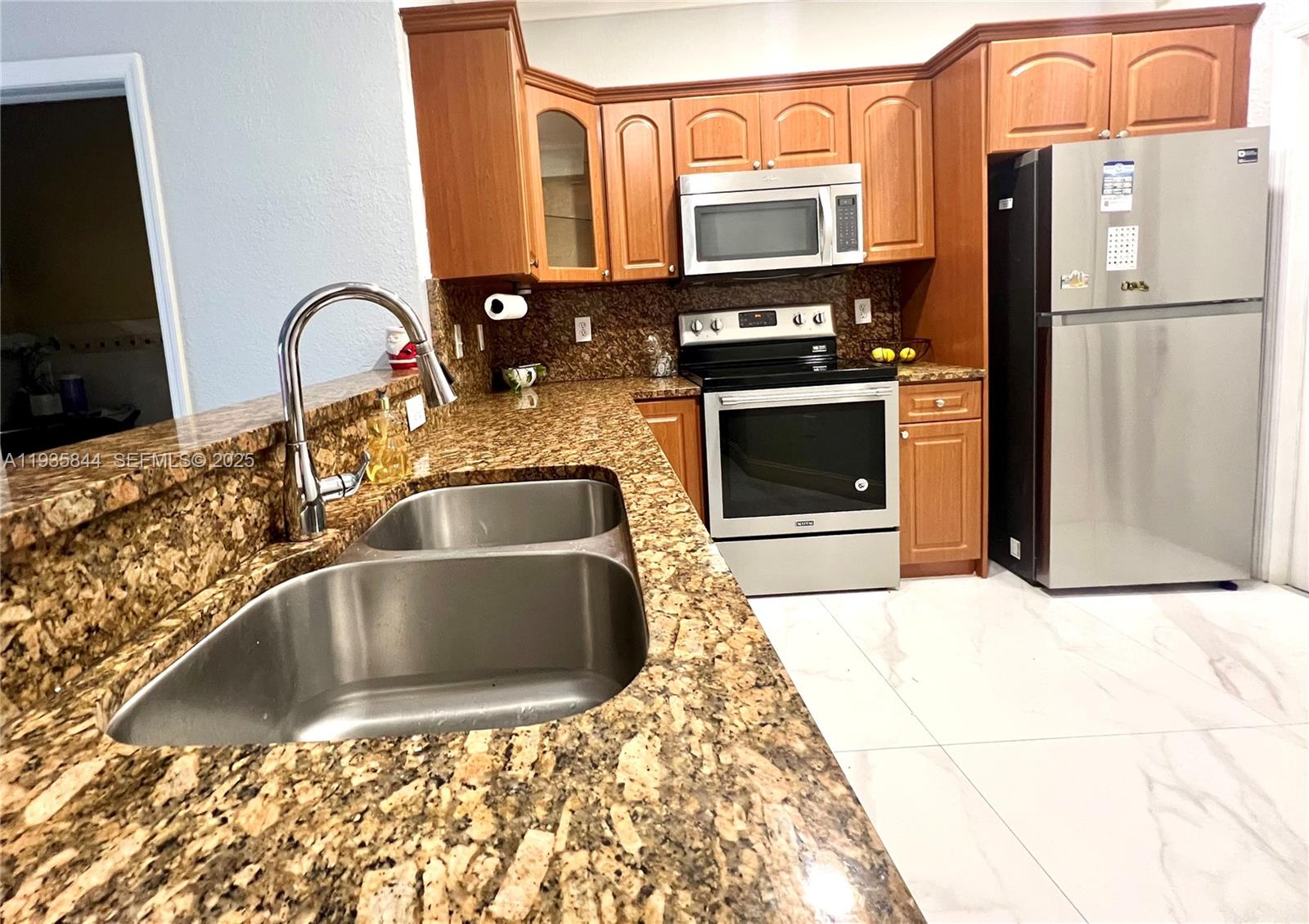 17014 Southwest 39th Street Miramar, FL 33027 - Photo 4 of 11 a kitchen with granite countertop a refrigerator and a sink
