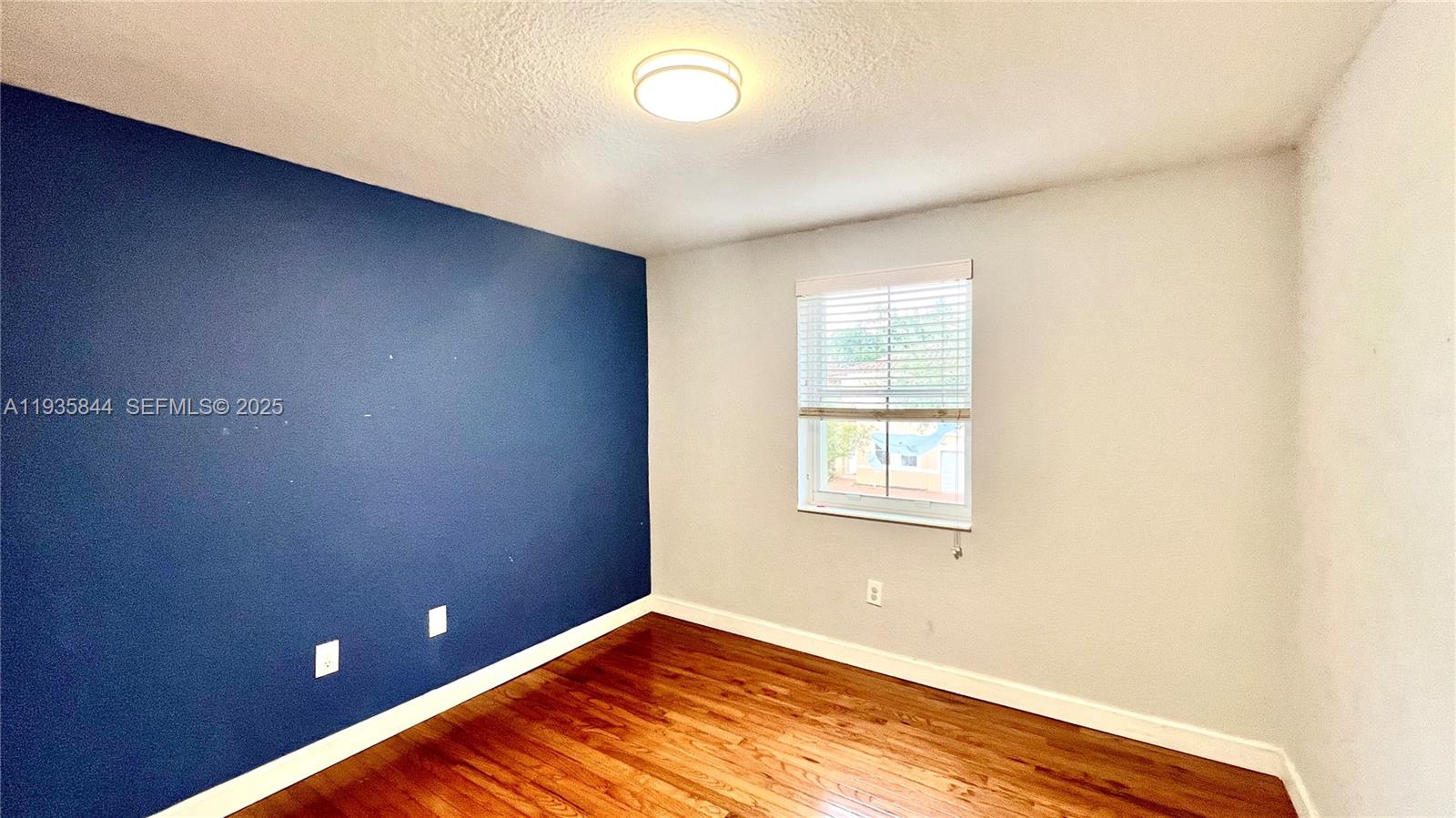 17014 Southwest 39th Street Miramar, FL 33027 - Photo 8 of 11 an empty room with wooden floor and windows