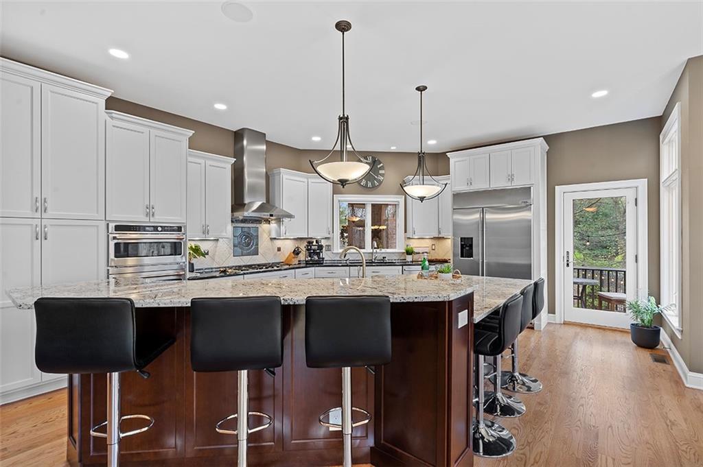 198 Camp Meeting Rd Extension Sewickley, PA 15143 - Photo 13 of 50 a kitchen with stainless steel appliances granite countertop a sink a stove a refrigerator and island with wooden floor
