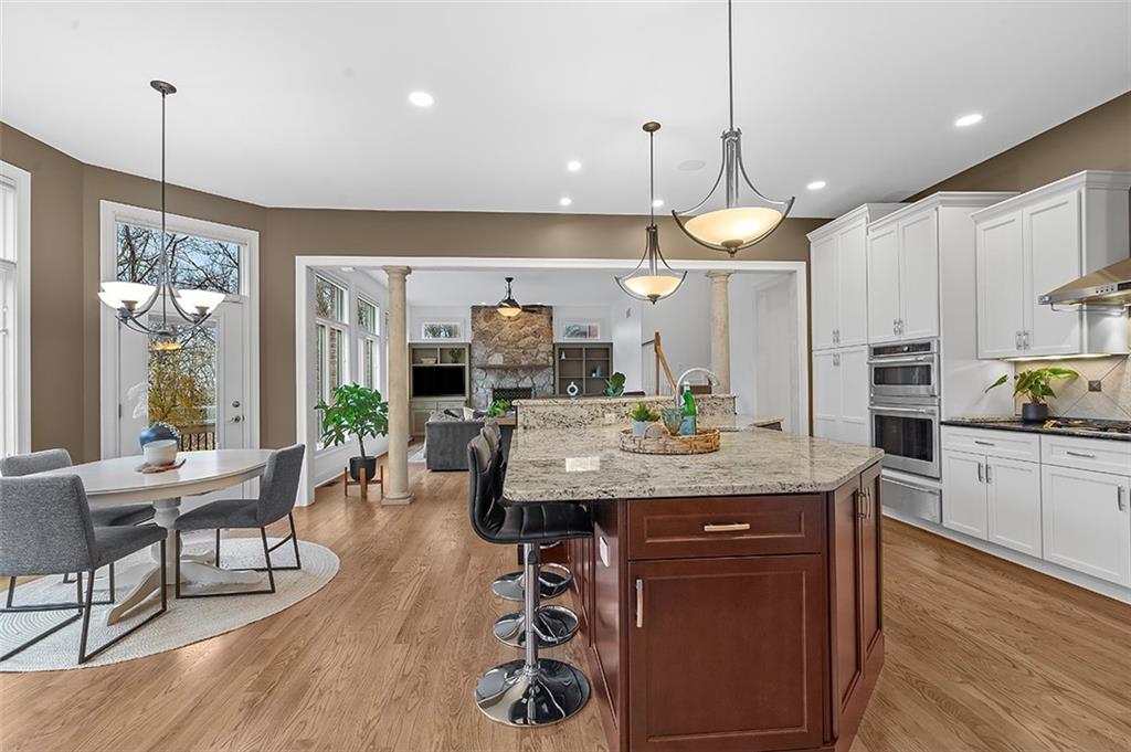 198 Camp Meeting Rd Extension Sewickley, PA 15143 - Photo 15 of 50 a kitchen with stainless steel appliances granite countertop wooden floors wooden cabinets a dining table and chairs