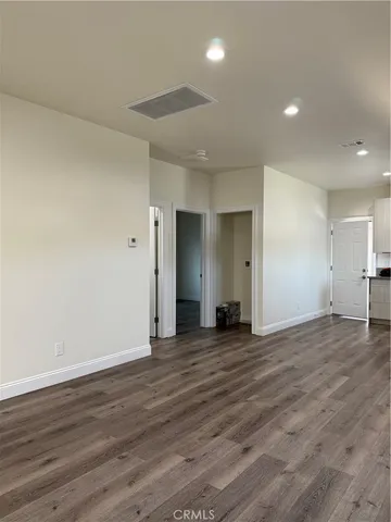 a view of an empty room with wooden floor