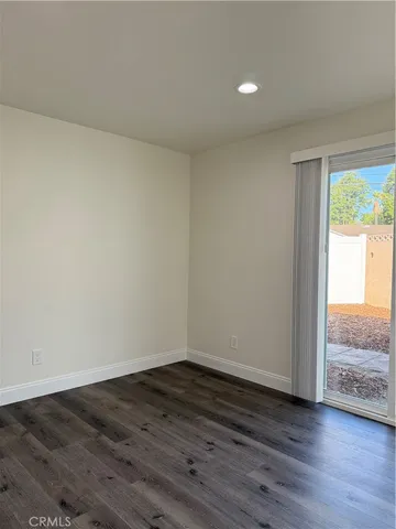 a view of an empty room and wooden floor and a window