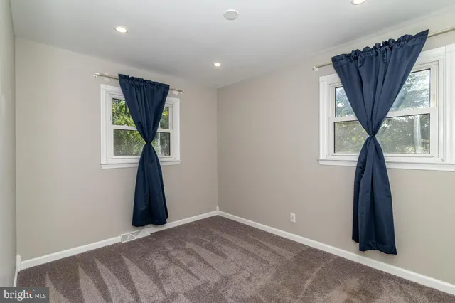 an empty room with a window and a walk in closet