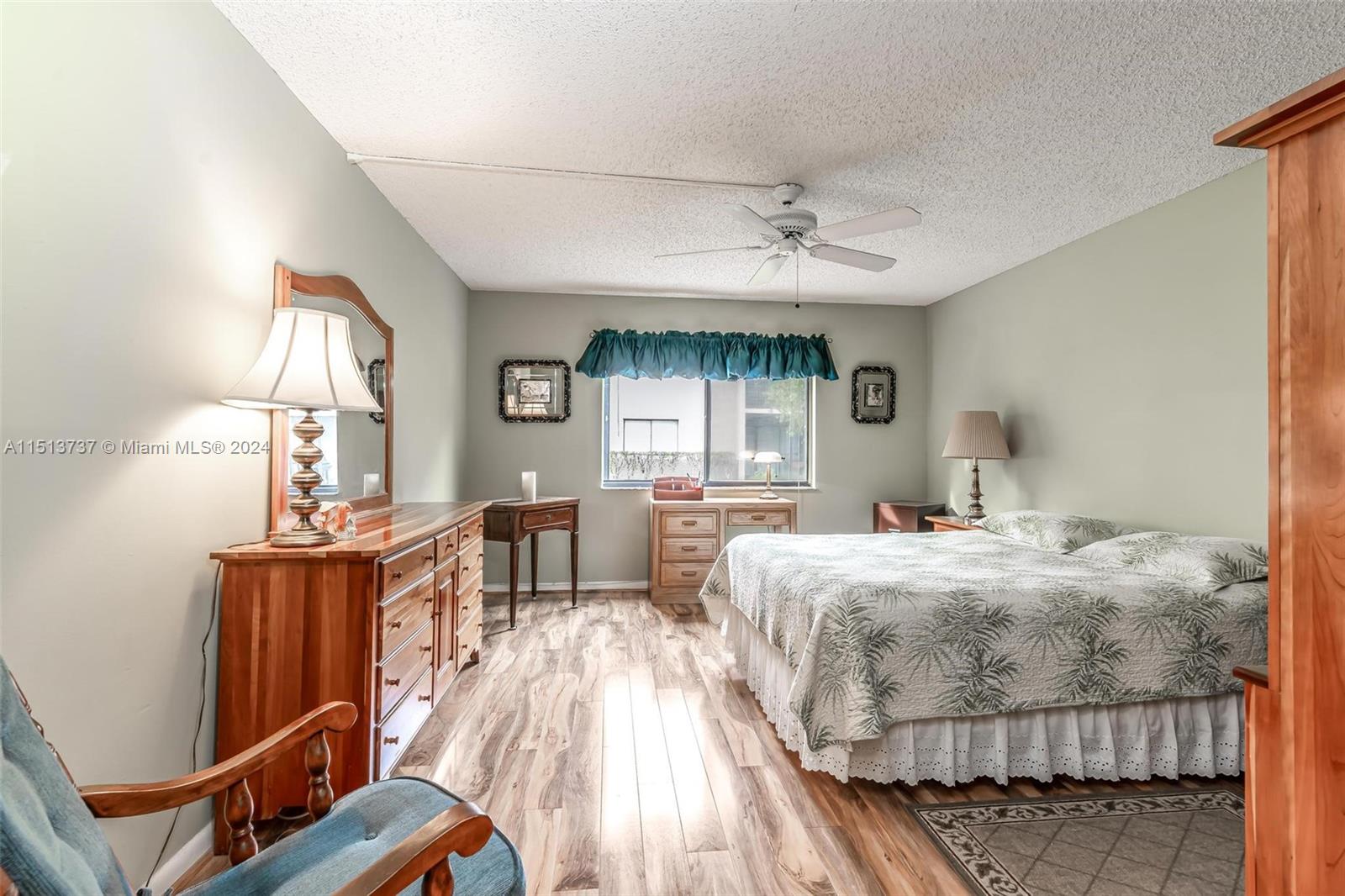 304 Racquet Club Road, Unit 101 Weston, FL 33326 - Photo 13 of 29 a bedroom with furniture and wooden floor