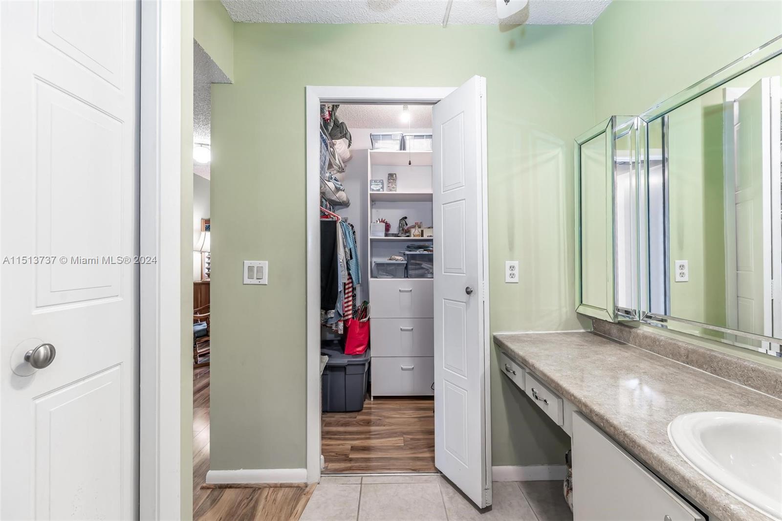 304 Racquet Club Road, Unit 101 Weston, FL 33326 - Photo 15 of 29 a bathroom with a granite countertop shower a sink and a mirror