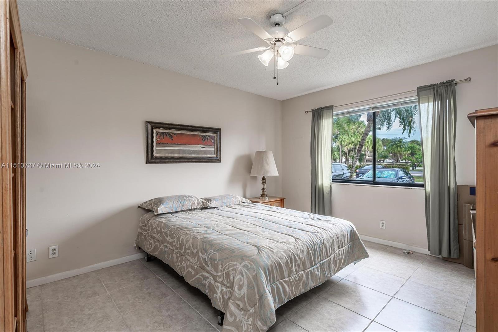 304 Racquet Club Road, Unit 101 Weston, FL 33326 - Photo 16 of 29 a bedroom with a bed and a chandelier