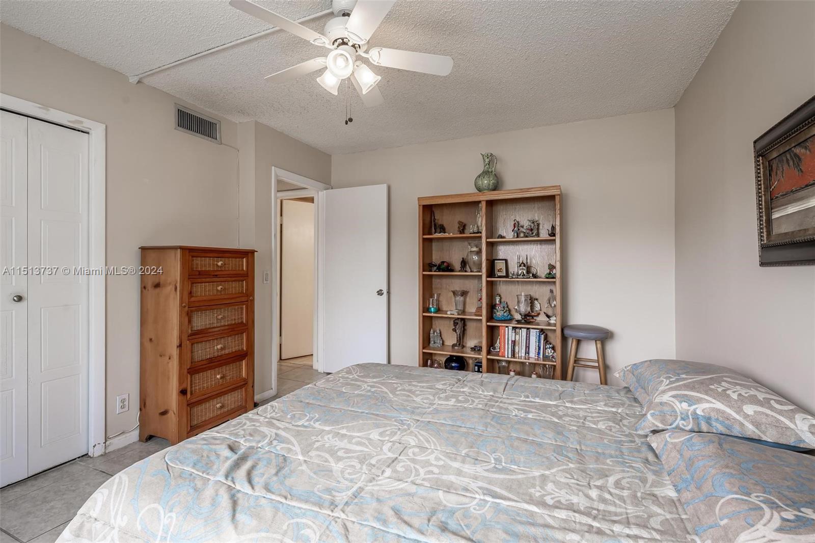 304 Racquet Club Road, Unit 101 Weston, FL 33326 - Photo 17 of 29 a bedroom with a bed and a chandelier