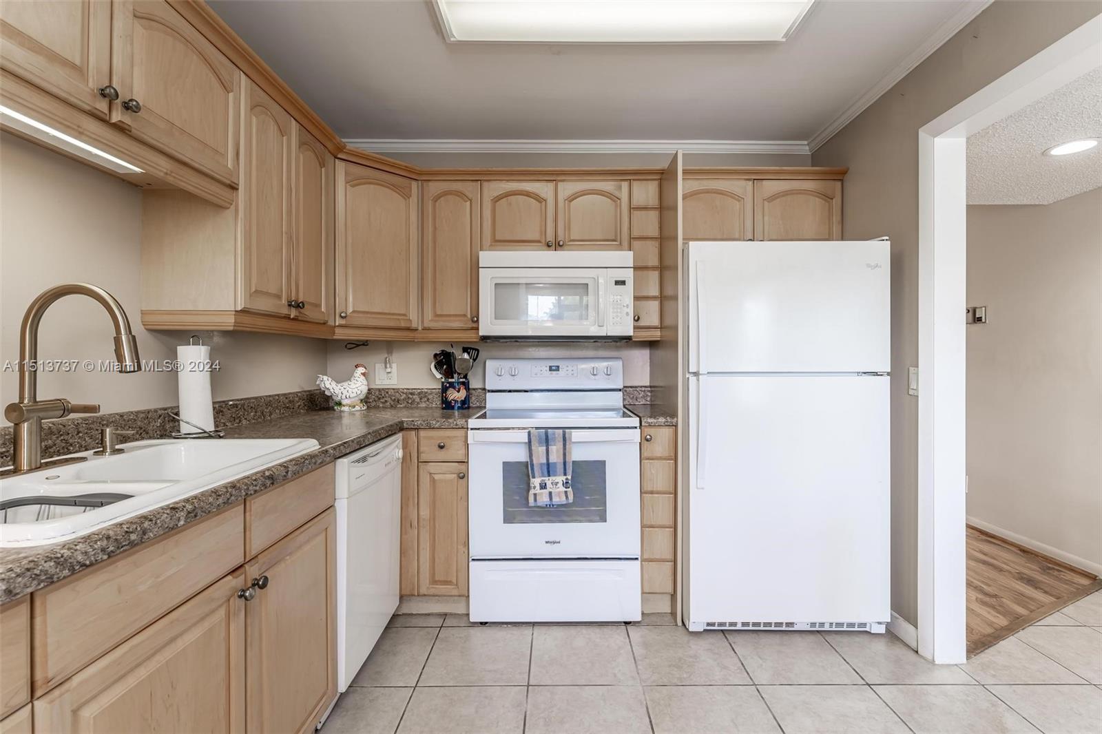 304 Racquet Club Road, Unit 101 Weston, FL 33326 - Photo 4 of 29 a kitchen with a refrigerator sink and cabinets