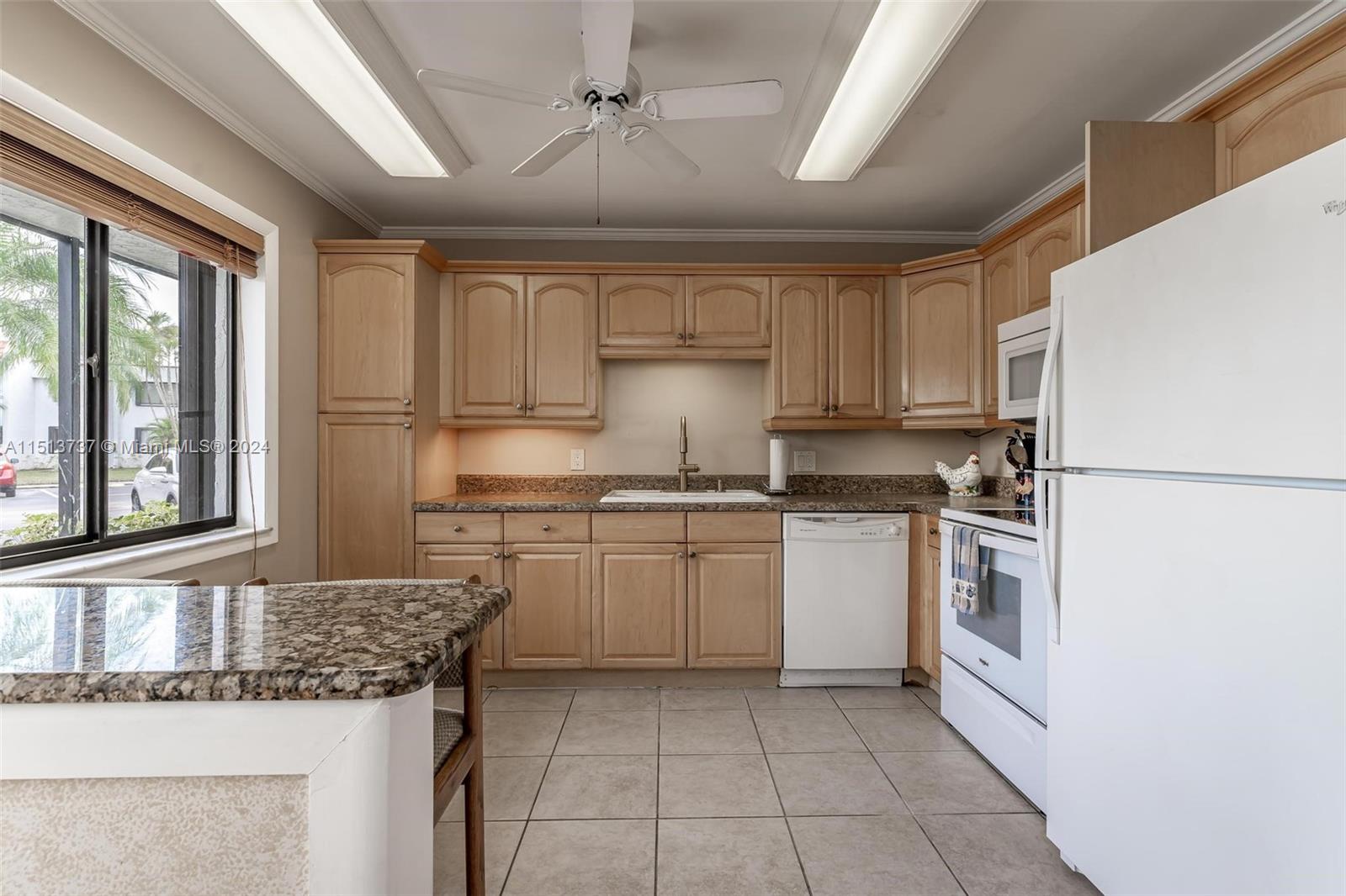 304 Racquet Club Road, Unit 101 Weston, FL 33326 - Photo 5 of 29 a kitchen with a sink stove and refrigerator