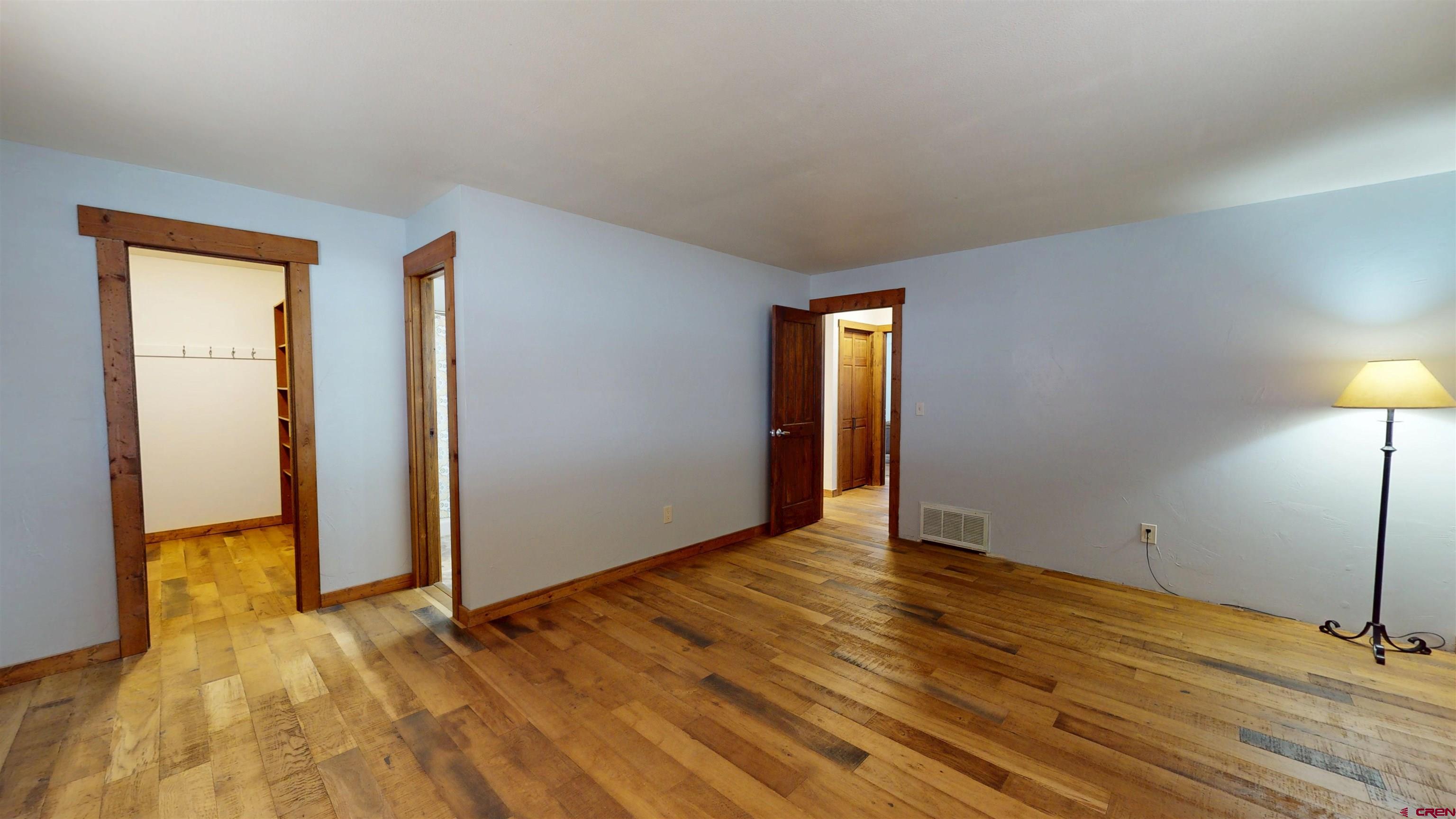 577 Pashuta Drive Gunnison, CO 81230 - Photo 16 of 41 an empty room with wooden floor and bathroom view