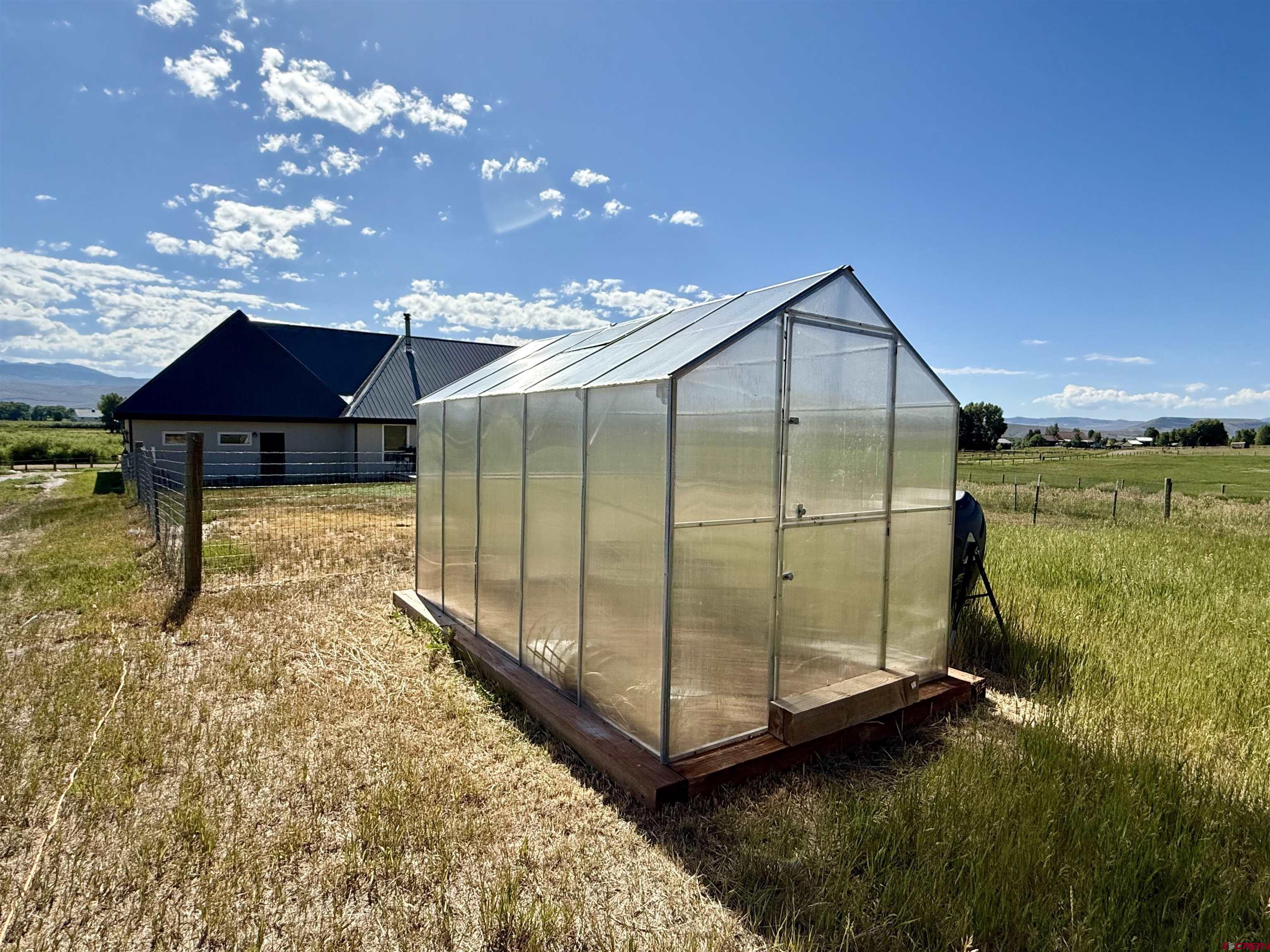 577 Pashuta Drive Gunnison, CO 81230 - Photo 38 of 41 a backyard of a house with table and chairs under an umbrella