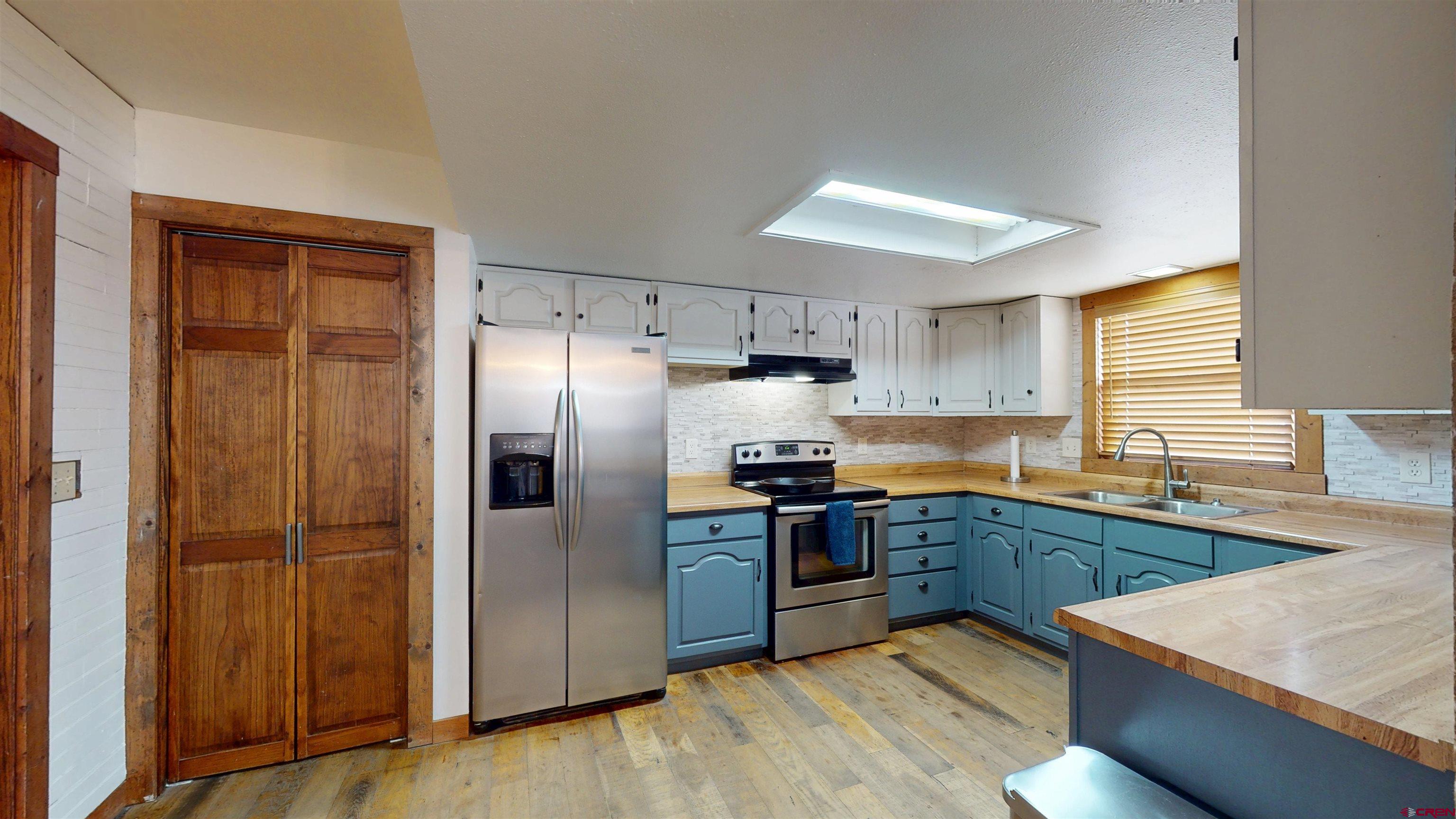 577 Pashuta Drive Gunnison, CO 81230 - Photo 9 of 41 a kitchen with stainless steel appliances granite countertop a refrigerator a sink dishwasher a stove with wooden cabinets and floor