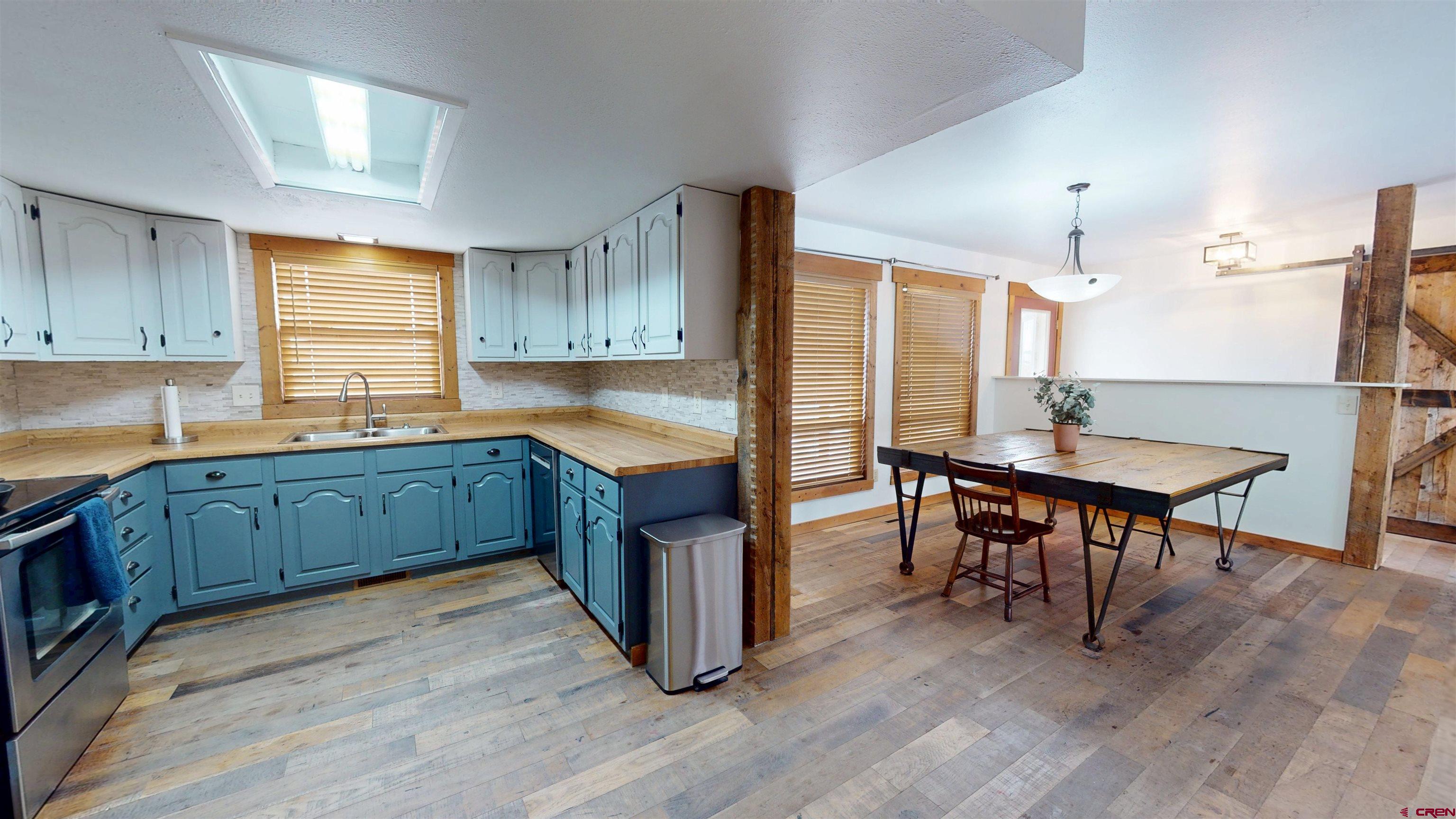 577 Pashuta Drive Gunnison, CO 81230 - Photo 10 of 41 a kitchen with granite countertop wooden floors and wooden cabinets