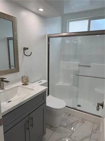 a bathroom with a sink a toilet and shower