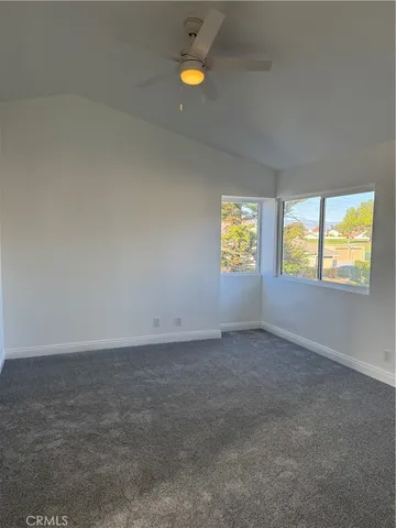 an empty room with windows and ceiling fan view