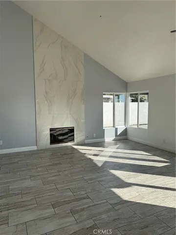 a view of empty room with a fireplace and windows
