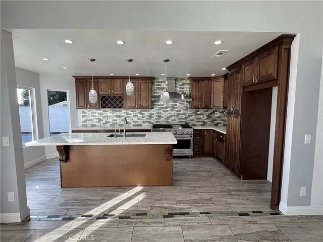 a large kitchen with stainless steel appliances granite countertop a large counter top and a wooden floors