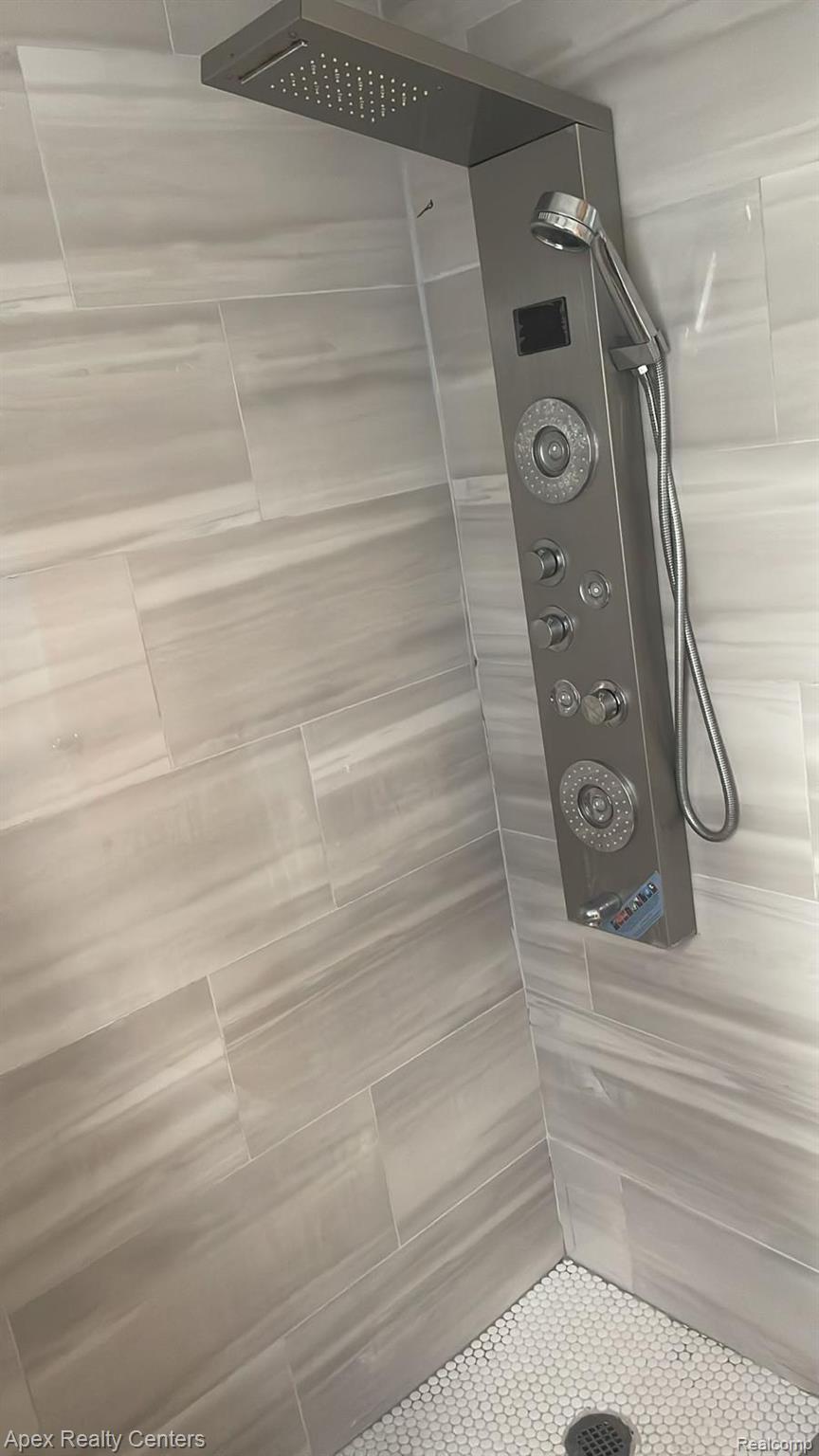 6730 Forrer Street Detroit, MI 48228 - Photo 4 of 10 Modern shower system with a rainfall showerhead, handheld sprayer, and multiple body jets