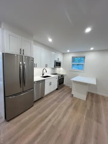 a kitchen with stainless steel appliances a refrigerator sink and cabinets