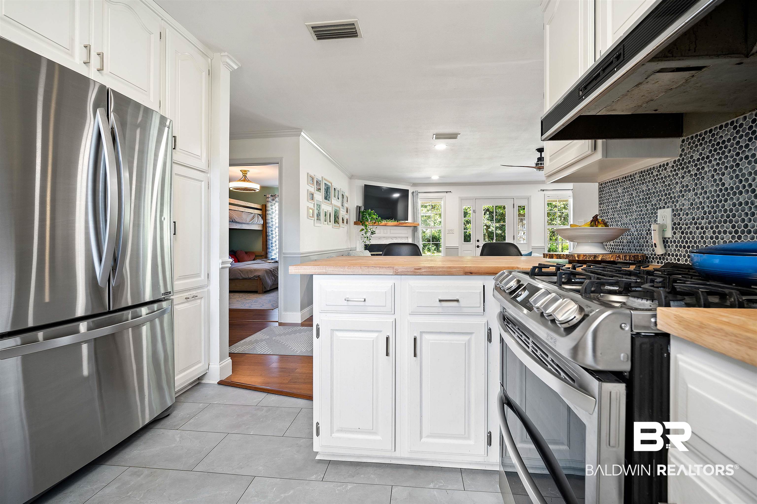 808 Michigan Avenue Fairhope, AL 36532 - Photo 11 of 33 Kitchen featuring light tile patterned floors, tasteful backsplash, butcher block countertops, white cabinetry, and appliances with stainless steel finishes