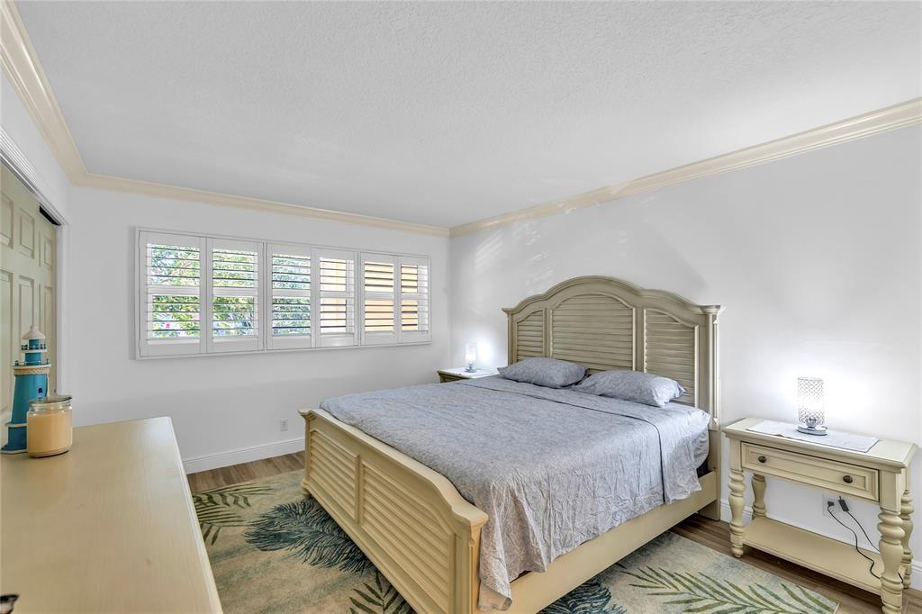 3150 Northeast 48th Court, Unit 204 Lighthouse Point, FL 33064 - Photo 15 of 28 a bedroom with a bed and a window