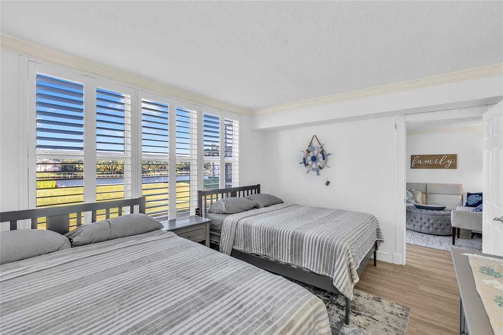 3150 Northeast 48th Court, Unit 204 Lighthouse Point, FL 33064 - Photo 17 of 28 a bedroom with two beds and a large window