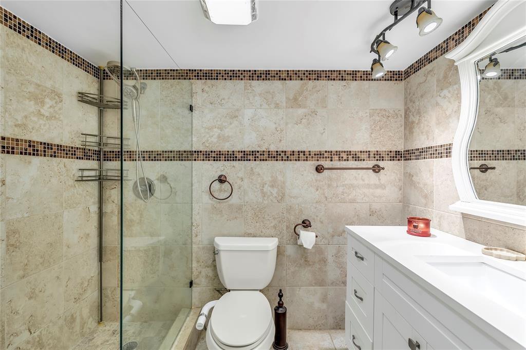 3150 Northeast 48th Court, Unit 204 Lighthouse Point, FL 33064 - Photo 19 of 28 a bathroom with a sink a toilet and shower