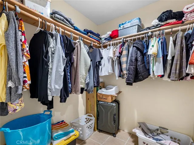 a view of walk in closet with clothes and shoes