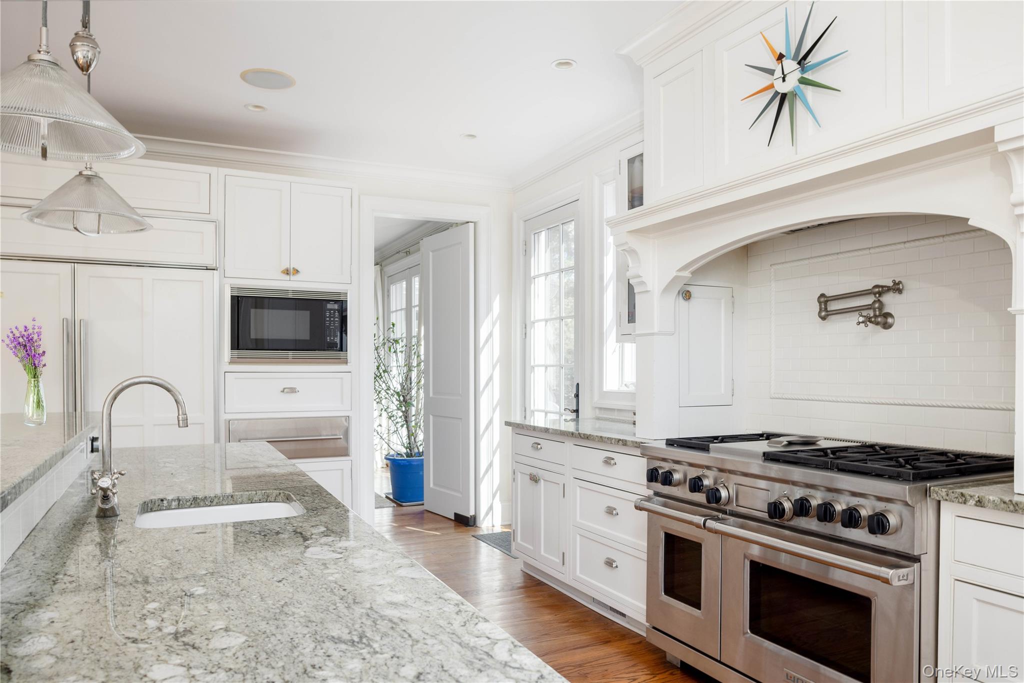 53 Cedar Lane West Remsenburg, NY 11960 - Photo 17 of 38 Kitchen featuring built in microwave, ornamental molding, range with two ovens, wood finished floors, and a sink