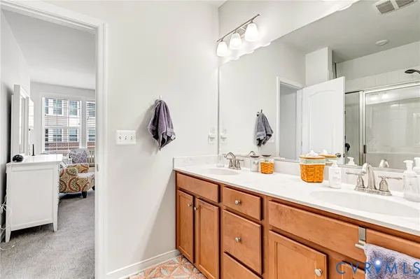 a en suite bathroom with a sink double vanity and mirror