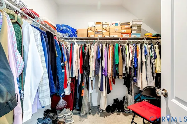 a view of walk in closet with clothes and shoes