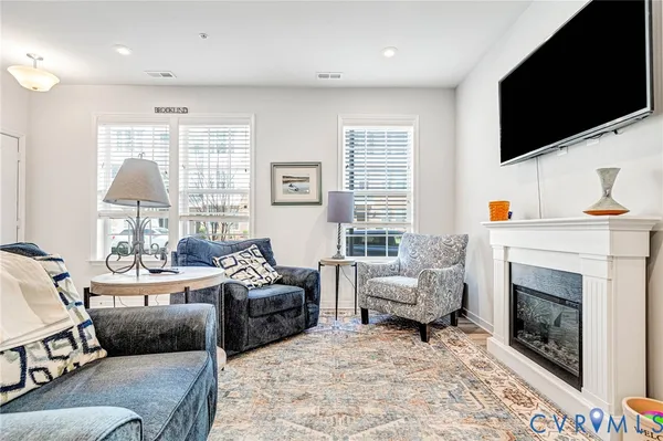 a living room with furniture a flat screen tv and a fireplace