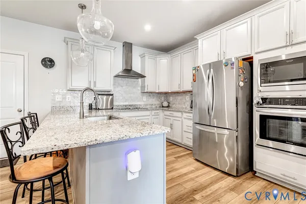 a kitchen with stainless steel appliances granite countertop a sink refrigerator and cabinets